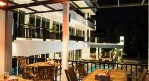 eine Terrasse mit Tischen und Stühlen und ein Gebäude in der Unterkunft Amin Resort in Ban Thalat Choeng Thale