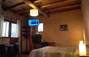 una habitación con mesa y TV en una casa en Posada Cobodemar en Mar de Cobo