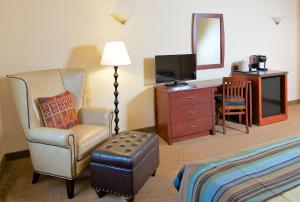 a hotel room with a chair and a desk with a television at Grande Denali Lodge in McKinley Park
