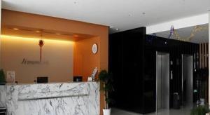 a lobby with a counter and a clock on the wall at Jinjiang Inn Yantai Fushan District Fuhai Road in Yantai