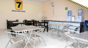 eine Gruppe von Tischen und Stühlen in einem Raum in der Unterkunft Super OYO 635 Seven Days Hotel in Kampong Sempalit Hilir
