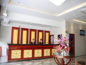 zwei Frauen stehen an der Rezeption in einer Lobby in der Unterkunft GreenTree Inn Shanghai Luojing Express Hotel in Luojing