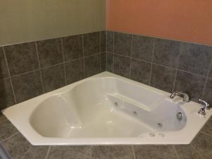 a bath tub with two faucets in a bathroom at The Inn in Monaca