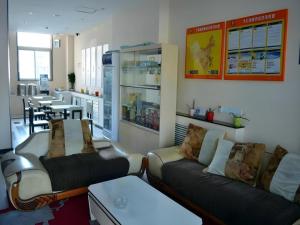 a living room with two couches and a table at 7 Days Inn Yantai Dahaiyang Raod Railway Station in Yantai