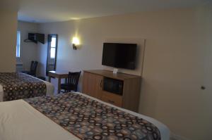 a hotel room with two beds and a flat screen tv at Seahorse Inn in Wildwood