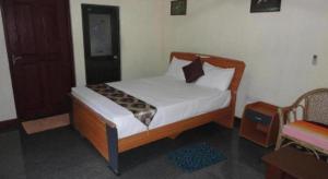 Un dormitorio con una cama con marco de madera. en Inn On The Tree, en Kibissa