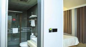 a bathroom with a shower and a toilet and a bed at GreenTree Inn Jiangsu Suqian Yiwu Business Center Fukang Avenue Express Hotel in Suqian +176 photos