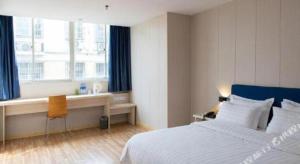 ein Schlafzimmer mit Bett, Schreibtisch und Fenster in der Unterkunft 7 Days Inn Changzhou Yancheng Technology Metro Station in Changzhou