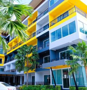 a building with palm trees in front of it at Eurotel Hotel in Kanchanaburi