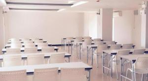 an empty room with tables and white chairs at Eurotel Hotel in Kanchanaburi