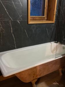 a white bath tub sitting under a window in a bathroom at Chalet coeur d'alpage La Plagne Les Arcs in La Plagne Tarentaise