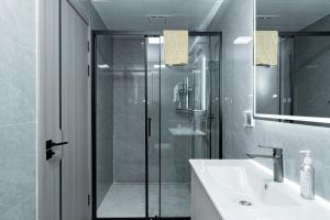 une salle de bain avec une douche en verre et un lavabo dans l'établissement Diamond Ivy Two Bedroom Apartment, Swimming pool, gym, workspace ,Wonderiss Homes Kileleshwa Living, à Nairobi 42 autres photos