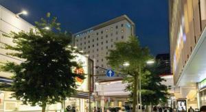 a city street at night with buildings and trees at KEIKYU EX INN Keikyu Kawasaki-Station in Kawasaki