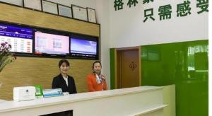 zwei Frauen, die hinter einem Tresen in einem Raum stehen in der Unterkunft Vatica Yangzhou Dongguan Street Hotel in Yangzhou