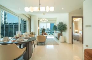 a living room with a table and chairs at Zapbed House -Elegant 1 BR Apartment Grand Bleu Emaar Beachfront in Dubai