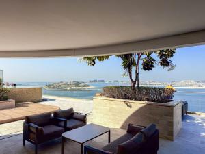 an outdoor patio with a view of the water at Zapbed House -Elegant 1 BR Apartment Grand Bleu Emaar Beachfront in Dubai