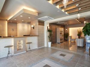 a lobby with a bar and a table and chairs at Ryuka Hotel Naha in Asato