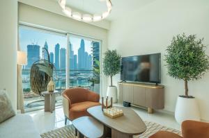 a living room with a tv and a large window at Zapbed House -Elegant 1 BR Apartment Grand Bleu Emaar Beachfront in Dubai