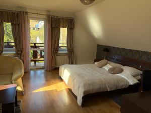 a bedroom with a bed and a large window at Willa Pod Starą Skocznią in Wisła