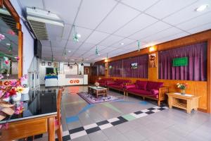 eine Lobby mit roten Sofas und Tischen in einem Zimmer in der Unterkunft OYO 90929 DJ Hotel in Kampung Damar Laut