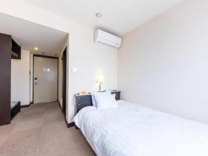 une chambre avec un grand lit blanc dans une pièce dans l'établissement Tabist Hotel New Osamura Sabae, à Sabae