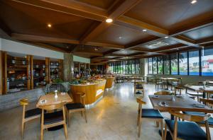 ein Restaurant mit Tischen und Stühlen und eine Bar in der Unterkunft Sabah Oriental Hotel in Kota Kinabalu