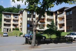 Un edificio de apartamentos con coches aparcados delante. en Ferienwohnung Bergblick, en Bad Harzburg