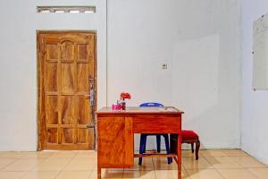 einen Holztisch mit zwei Stühlen und einer Holztür in der Unterkunft SPOT ON 93592 Pondok Backpackers Ardafa Jogja in Manisrenggo + 33 Fotos