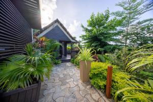 un giardino con piante in vaso e una casa di Résidence Kazela a Chirongui