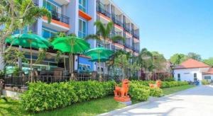 ein Gebäude mit grünen Sonnenschirmen davor in der Unterkunft Evergreen Resort Cha-am in Cha-am