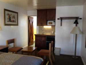 a room with a kitchen with a bed and a table at Sands Motel in Cheyenne