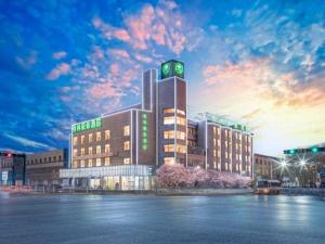 a large building with a clock on top of it at GreenTree Inn Geermu Walking Street Business Hotel in Golmud