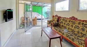 un salon avec un canapé et une table basse dans l'établissement Capital O 93124 Lombok Northis Homestay, à Paloh 28 autres photos