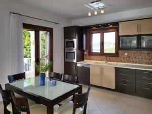 Il comprend une cuisine avec une table, des chaises et une table. dans l'établissement villa agnanti 'Despoina' with private pool, à Skouloúfia