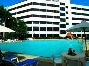 a large swimming pool with chairs and a building at Ayutthaya Grand Hotel in Ban Han Tra Fang Nua