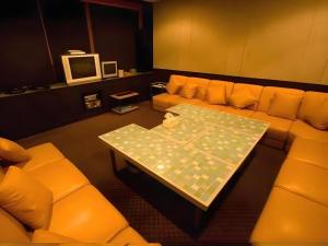 a living room with orange couches and a table at Ayutthaya Grand Hotel in Ban Han Tra Fang Nua