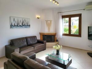 un salon avec un canapé et une cheminée dans l'établissement villa agnanti 'Despoina' with private pool, à Skouloúfia