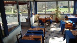 a restaurant with blue tables and chairs and windows at Hotel Pikassaria in Sare