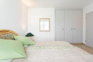 a bedroom with a large bed with green pillows at Golf Ranch, 1Er Stock in Ascona