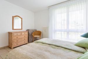 a bedroom with a bed and a dresser and a mirror at Golf Ranch, 1Er Stock in Ascona