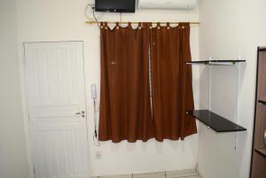 una habitación con una cortina marrón y una puerta en Lize Hotel Rodoviária, en Campinas