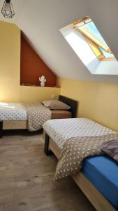 a bedroom with two beds and a skylight at Gîte Bambou, Beauval Zoo in Seigy