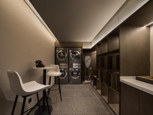 eine Waschküche mit 2 Waschmaschinen und Trocknern in der Unterkunft 上海静安寺西康路亚朵酒店 in Shanghai