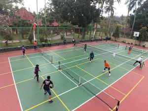 un gruppo di persone che giocano a tennis su un campo da tennis di Merumatta Senggigi Lombok a Senggigi