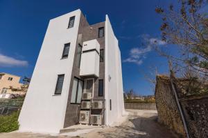 a white building with chairs in front of it at Triple Suite Villa BnB in Magong