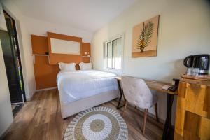 una camera da letto con un letto e una scrivania con una sedia di Résidence Kazela a Chirongui