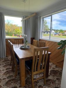 a dining room with a wooden table and chairs at Cosy & close to town in Te Anau