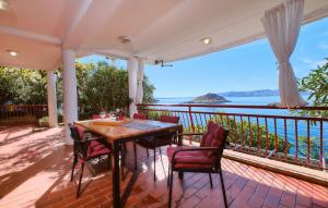 um alpendre com uma mesa e cadeiras e vista para o oceano em Melone Apartman 3 Senj by Villas Guide em Sveti Juraj