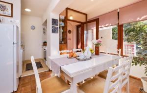 uma sala de jantar com uma mesa e cadeiras brancas em Melone Apartman 3 Senj by Villas Guide em Sveti Juraj