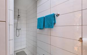 uma casa de banho com um chuveiro e toalhas azuis em Melone Apartman 3 Senj by Villas Guide em Sveti Juraj